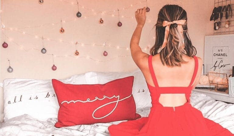 woman pinning xmas decorations to wall