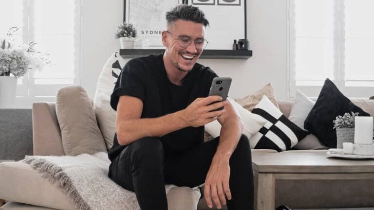 man in black t shirt and black jeans on mobile
