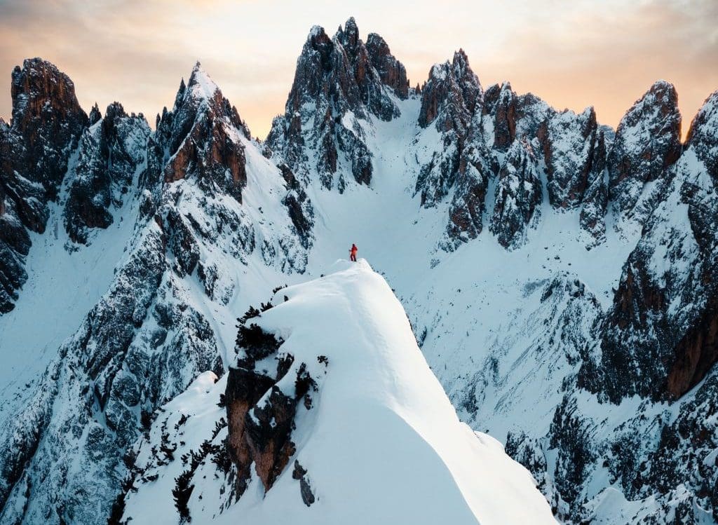 man on top of snowy cliff