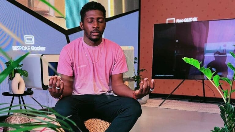 man on chair with pink t shirt and black jeans