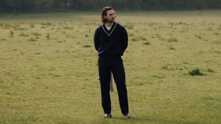 man in field dressed in all black