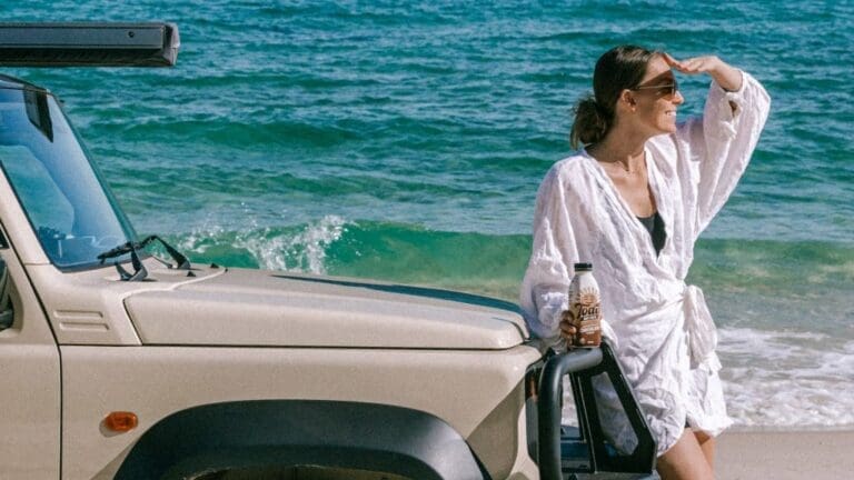 woman leaning on an SUV on the beach