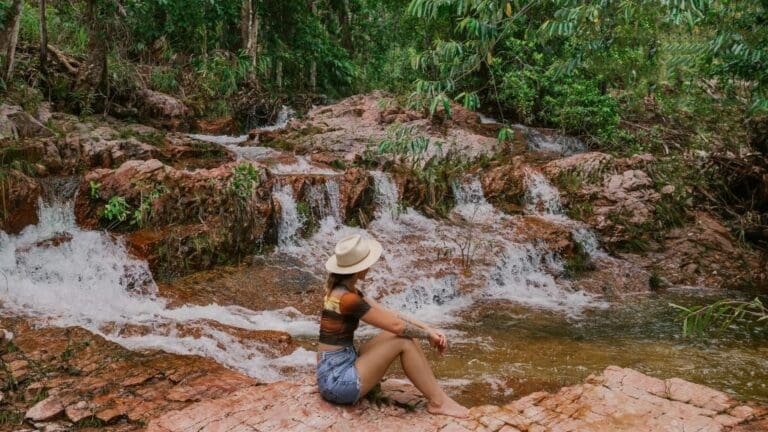 woman sitting in front of a waterfall