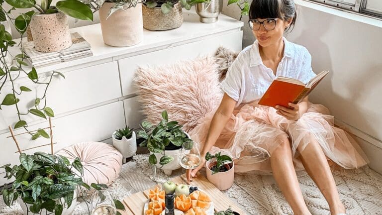 woman reading book sitting on floor