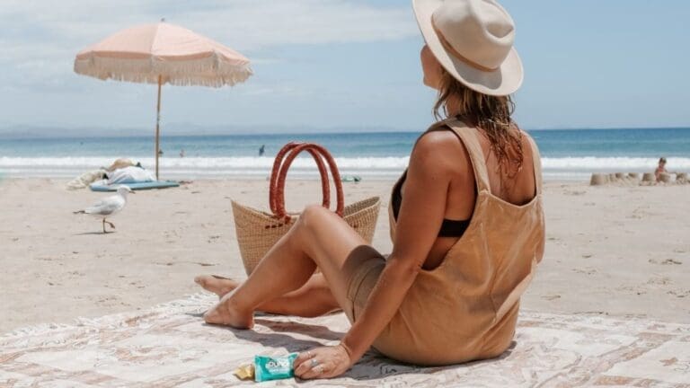 woman sitting on beach looking out to sea